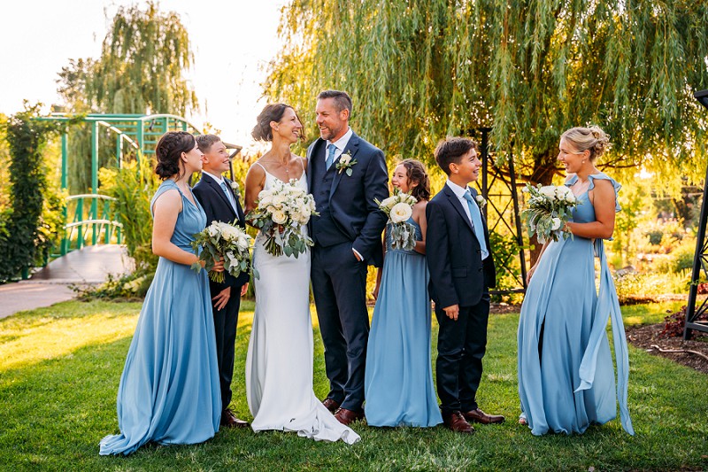 bride and groom with their kids walking and laughing